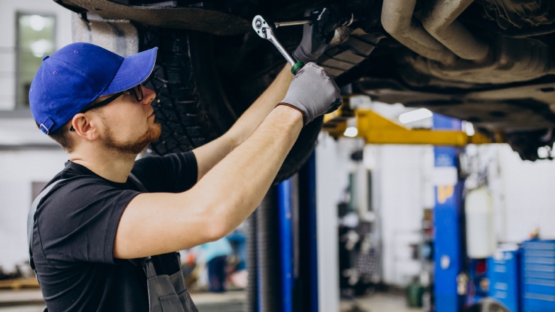 Técnico especializado en vehículos dándole atención a un auto.