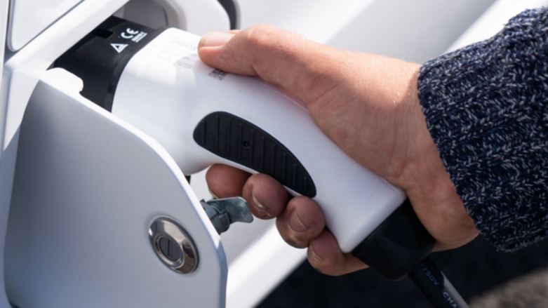 <p>Persona conectando un vehículo eléctrico para su carga.</p>