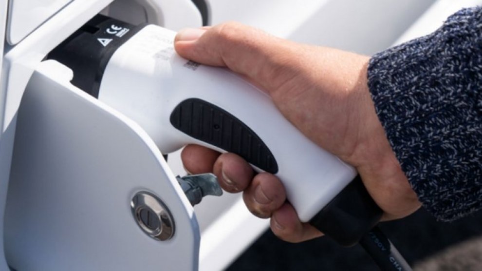 <p>Persona conectando un vehículo eléctrico para su carga.</p>